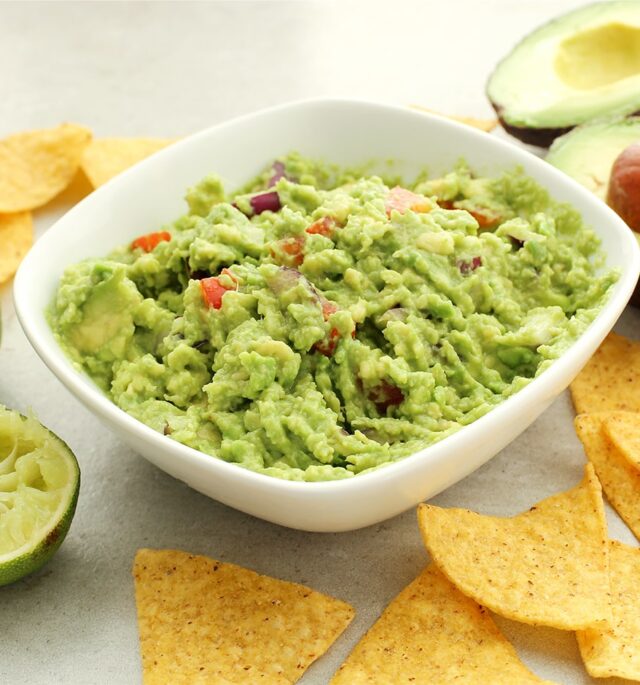 with avocado and chips in the background guacamole sauce