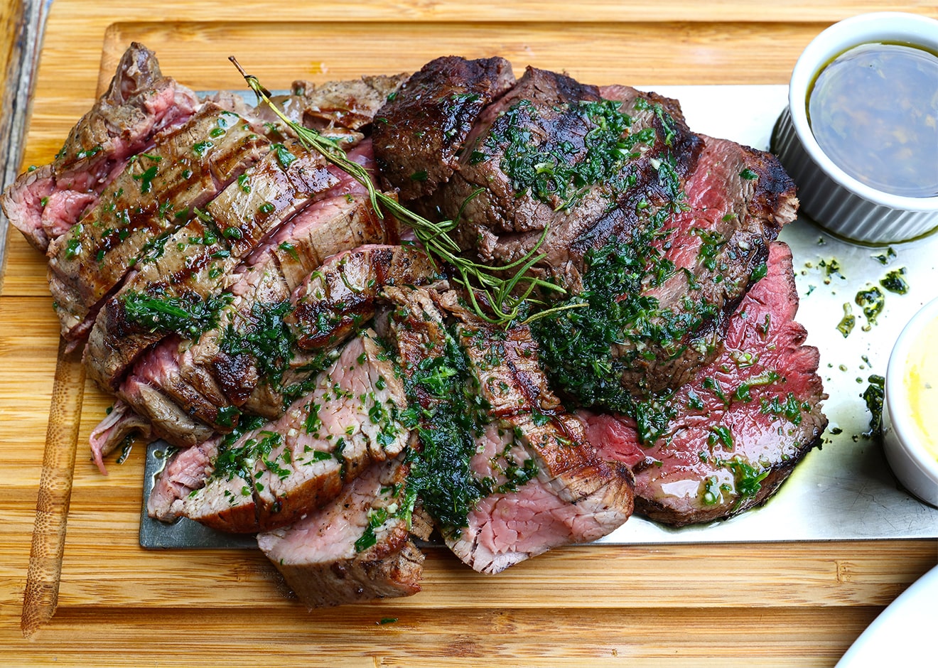 Chateaubriand garnished with parsley on a wooden tray