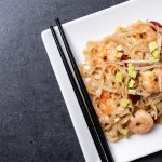 pad thai with shrimp vegetables black slate background