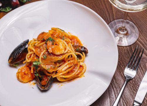top view of seafood spaghetti with mussels shrimp tomato sauce and parsley