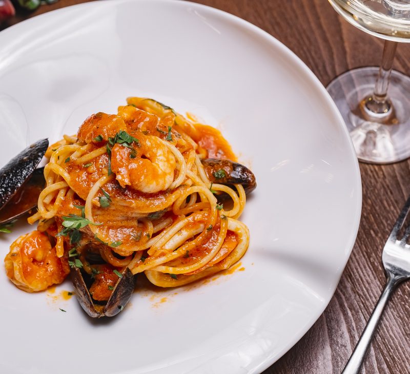 top view of seafood spaghetti with mussels shrimp tomato sauce and parsley